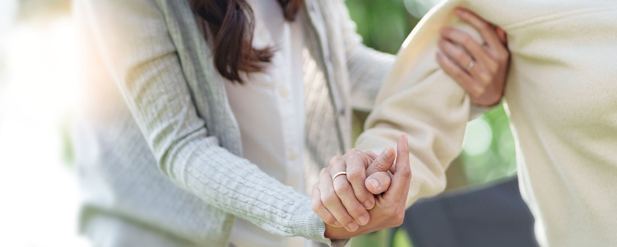 Eine weibliche Pflegekraft stÃƒÂ¼tz eine ÃƒÂ¤ltere Frau und hÃƒÂ¤lt ihr zur UnterstÃƒÂ¼tzung die Hand