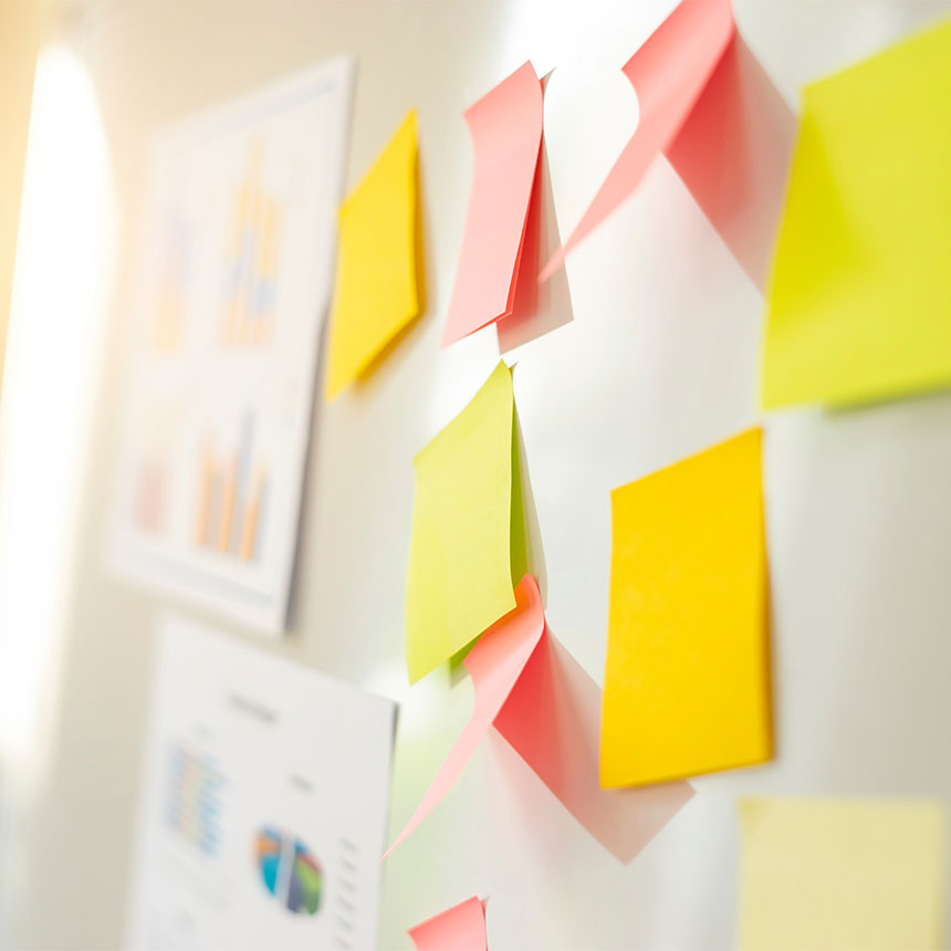 Mehrere Notizzettel kleben an einer Wand als Symbol für Workshops